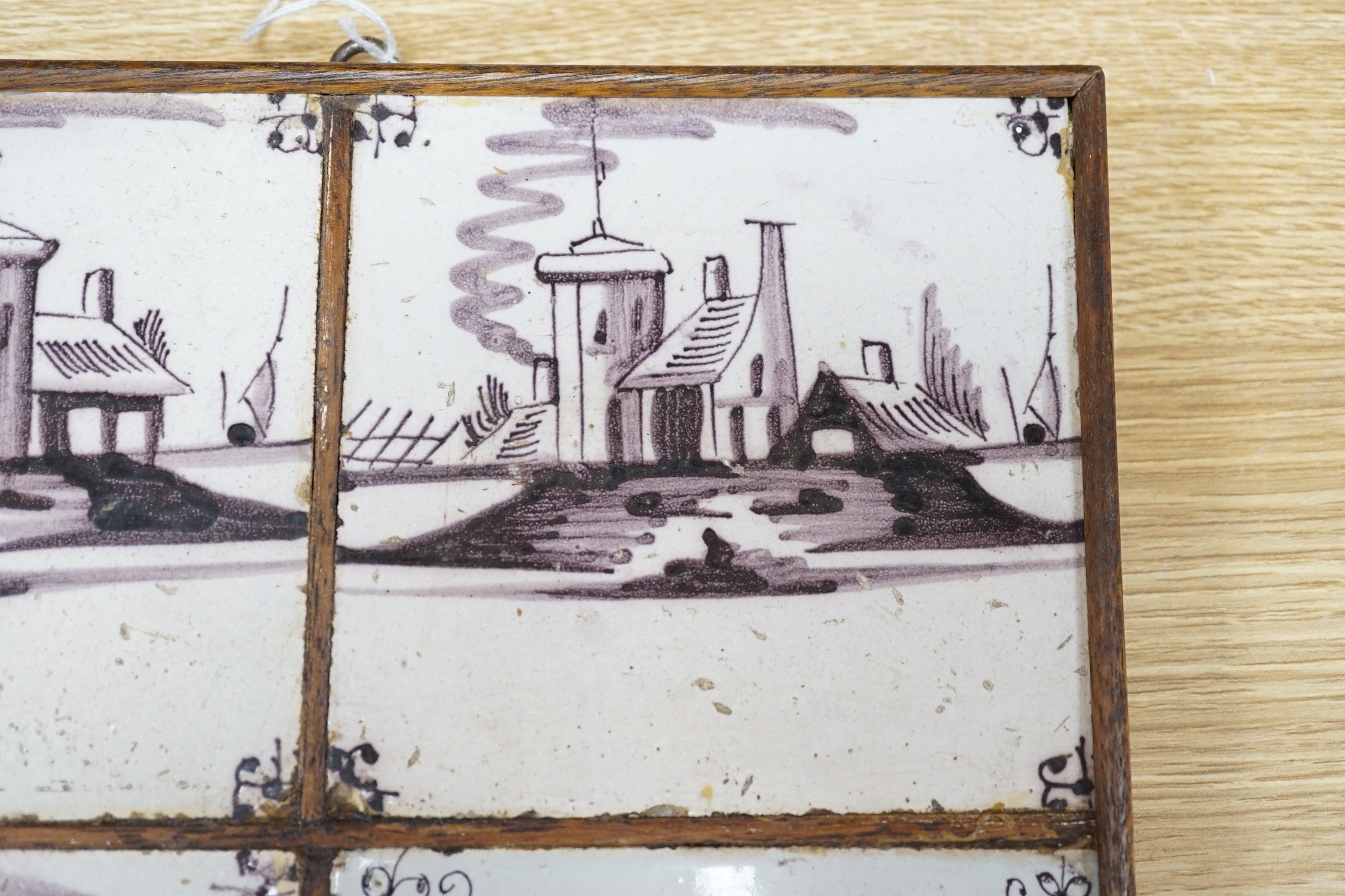 A set of four 18th century Dutch Delft manganese tiles decorated with buildings by a canal (frame 27cm)